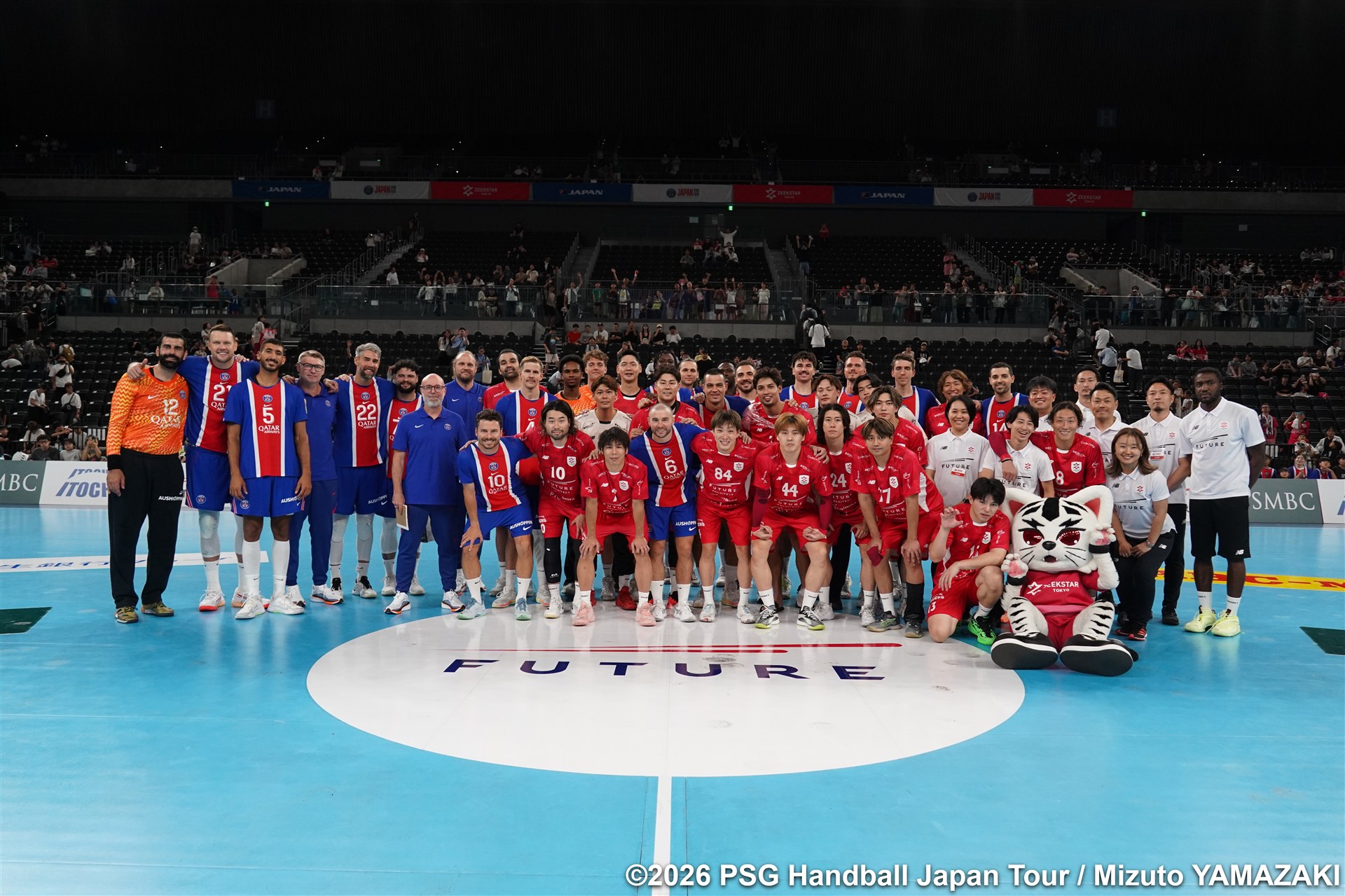 試合後、コート上で記念撮影する両チームの選手・スタッフ